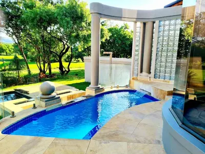 a swimming pool in a backyard with a gazebo at The Villa Luxe Hartbeespoort Golf and Wildlife Estate in Hartbeespoort