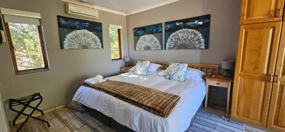a bedroom with a bed and two windows at Chestnut at Greenway Woods in White River