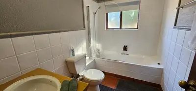 a bathroom with a toilet and a tub and a sink at Chestnut at Greenway Woods in White River