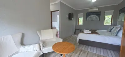 a bedroom with a bed and a table and a couch at Chestnut at Greenway Woods in White River
