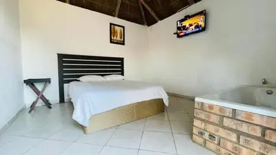a bedroom with a bed and a bath tub at De whytehouse Mogalatsane in Marble Hall