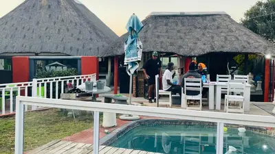 a resort with a swimming pool and a house with a roof at De whytehouse Mogalatsane in Marble Hall