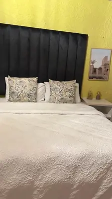 a large white bed with a black headboard and pillows at Harmony Spaces in Kempton Park