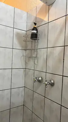 a bathroom with a tiled wall with a light on it at Harmony Spaces in Kempton Park