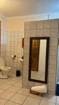 a bathroom with a mirror and a toilet at Harmony Spaces in Kempton Park