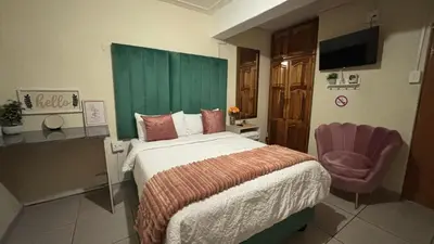 a bedroom with a bed with a green headboard and a chair at Harmony Spaces in Kempton Park