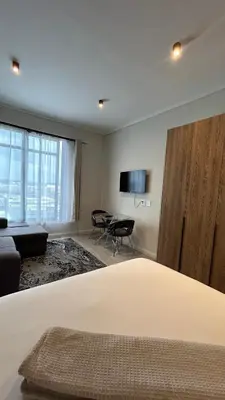 a bedroom with a bed and a living room at The Capital Trilogy Menlyn Maine Apartment in Pretoria