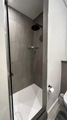 a shower with a glass door in a bathroom at The Capital Trilogy Menlyn Maine Apartment in Pretoria