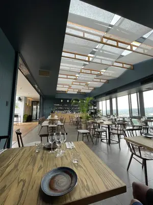a dining room with tables and chairs and windows at The Capital Trilogy Menlyn Maine Apartment in Pretoria