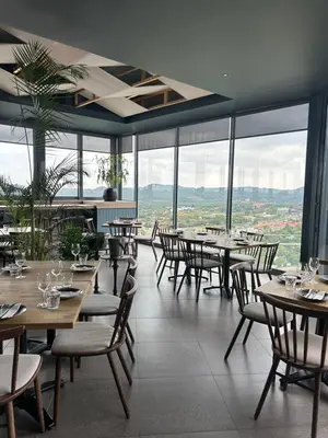 a restaurant with tables and chairs and large windows at The Capital Trilogy Menlyn Maine Apartment in Pretoria