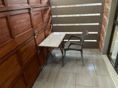 a table and a chair in a room at Ekhaya,private room with patio 1 in Mokopane