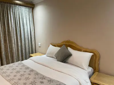 a bedroom with a bed with white sheets and pillows at Ekhaya,private room with patio 1 in Mokopane