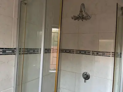 a shower with a glass door in a bathroom at Ekhaya,private room with patio 1 in Mokopane