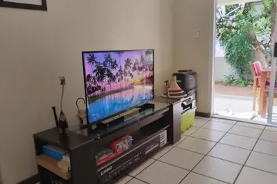 a living room with a flat screen tv on a entertainment center at Sunninghill apartment in Sandton