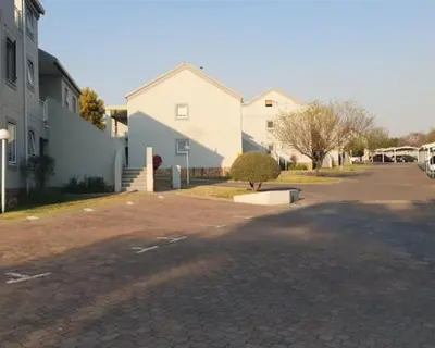 a street with houses and a tree in a driveway at Sunninghill apartment in Sandton