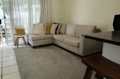 a living room with a white couch and a table at Sunninghill apartment in Sandton