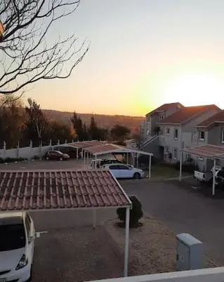 a parking lot with a white van parked in front of a house at Sunninghill apartment in Sandton