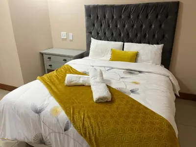 a bedroom with a bed with two towels on it at Private Room with patio 2 in Mokopane