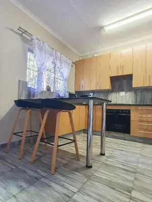 a kitchen with a table and two stools in it at Hippo's Rest in Ellisras