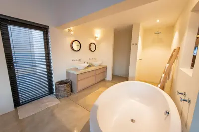 a bathroom with a large white tub and two sinks at Villa Aloe Vera in Hoedspruit