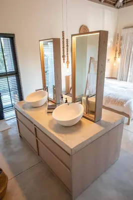 a bathroom with two sinks and mirrors on a counter at Villa Aloe Vera in Hoedspruit