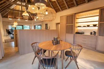 a dining room with a wooden table and chairs at Villa Aloe Vera in Hoedspruit