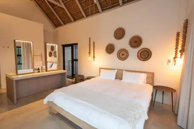 a bedroom with a large white bed and a mirror at Villa Aloe Vera in Hoedspruit