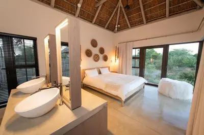 a bedroom with a bed and a large mirror at Villa Aloe Vera in Hoedspruit