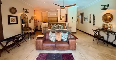 a large room with a bed and a leather couch at Kambaku River Lodge in Malelane
