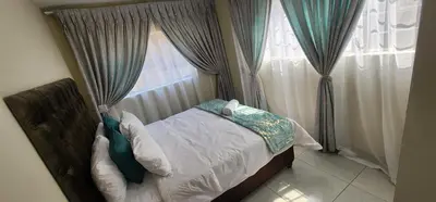 a bedroom with a bed and a window with curtains at 66 On RN in Midrand