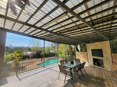 a pergola over a patio with a table and chairs at 66 On RN in Midrand