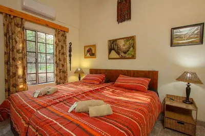 a bedroom with a bed with two towels on it at Holidayhouse Mhofu closeby Kruger National Park, South Africa in Marloth Park