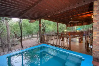 a house with a swimming pool and a deck at Holidayhouse Mhofu closeby Kruger National Park, South Africa in Marloth Park