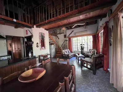 a living room with a wooden table and chairs at Holidayhouse Mhofu closeby Kruger National Park, South Africa in Marloth Park