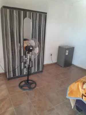 a room with a mirror and a fan on the floor at One night in Burgersfort