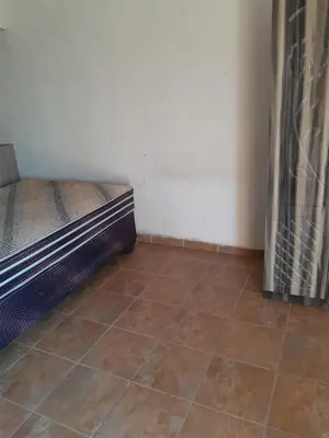 a small room with a bed and a tiled floor at One night in Burgersfort