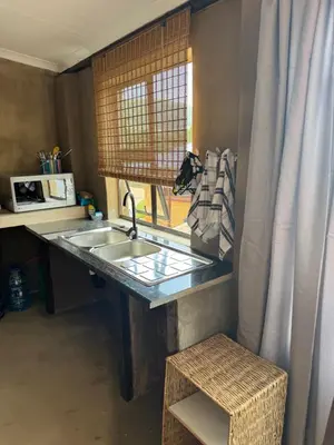 a kitchen with a sink and a window at Stone Cottage in Waterval Boven