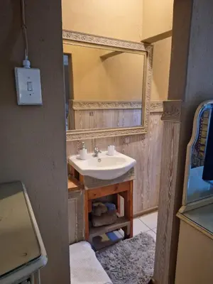 a bathroom with a sink and a mirror at Bosveld Gastehuis Bosveld Guesthouse