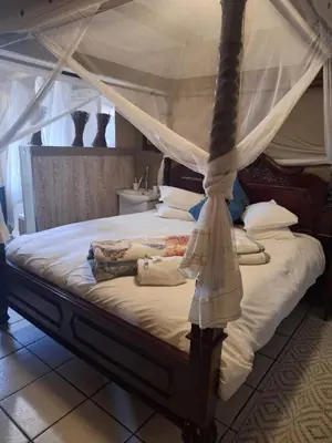 a bedroom with a bed with a canopy at Bosveld Gastehuis Bosveld Guesthouse