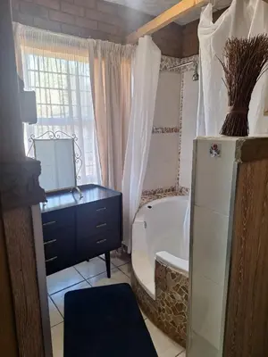 a bathroom with a tub and a sink and a toilet at Bosveld Gastehuis Bosveld Guesthouse