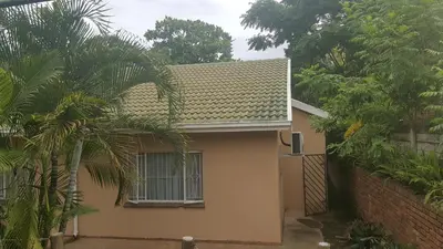 a house with a fence and a palm tree at Spring Acres Guesthouse in Nelspruit