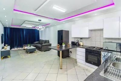 a kitchen and living room with purple lighting at The Villa in Midrand