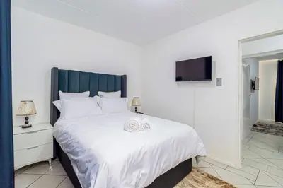 a bedroom with a large white bed with two wedding rings at The Villa in Midrand