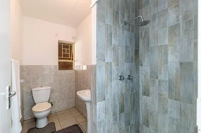 a bathroom with a toilet and a shower at The Villa in Midrand