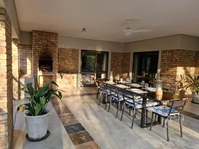 a dining room with a table and chairs at Tusker House Kruger in Marloth Park
