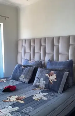 a bed with a blue comforter with dolls on it at Luxury Apartment At Erand Gardens Midrand in Midrand