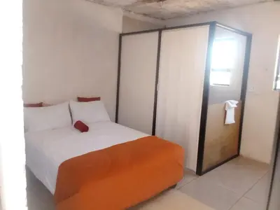 a bedroom with a bed and a sliding glass door at Mokoena Village guesthouse in Akasia