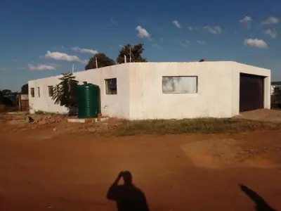 a shadow of a person standing in front of a building at Mokoena Village guesthouse in Akasia