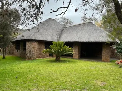 a large stone house with a grass roof at Soutpansberg Lodge Louis Trichardt