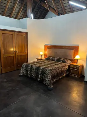 a bedroom with a bed and two night stands with lamps at Soutpansberg Lodge Louis Trichardt